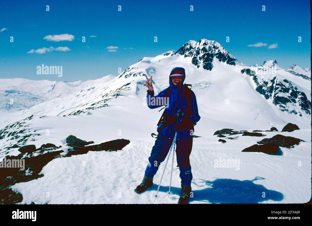 A woman back country skier makes a victory sign in the Coast Mountains of British Columbia, Canada. Stock Photo