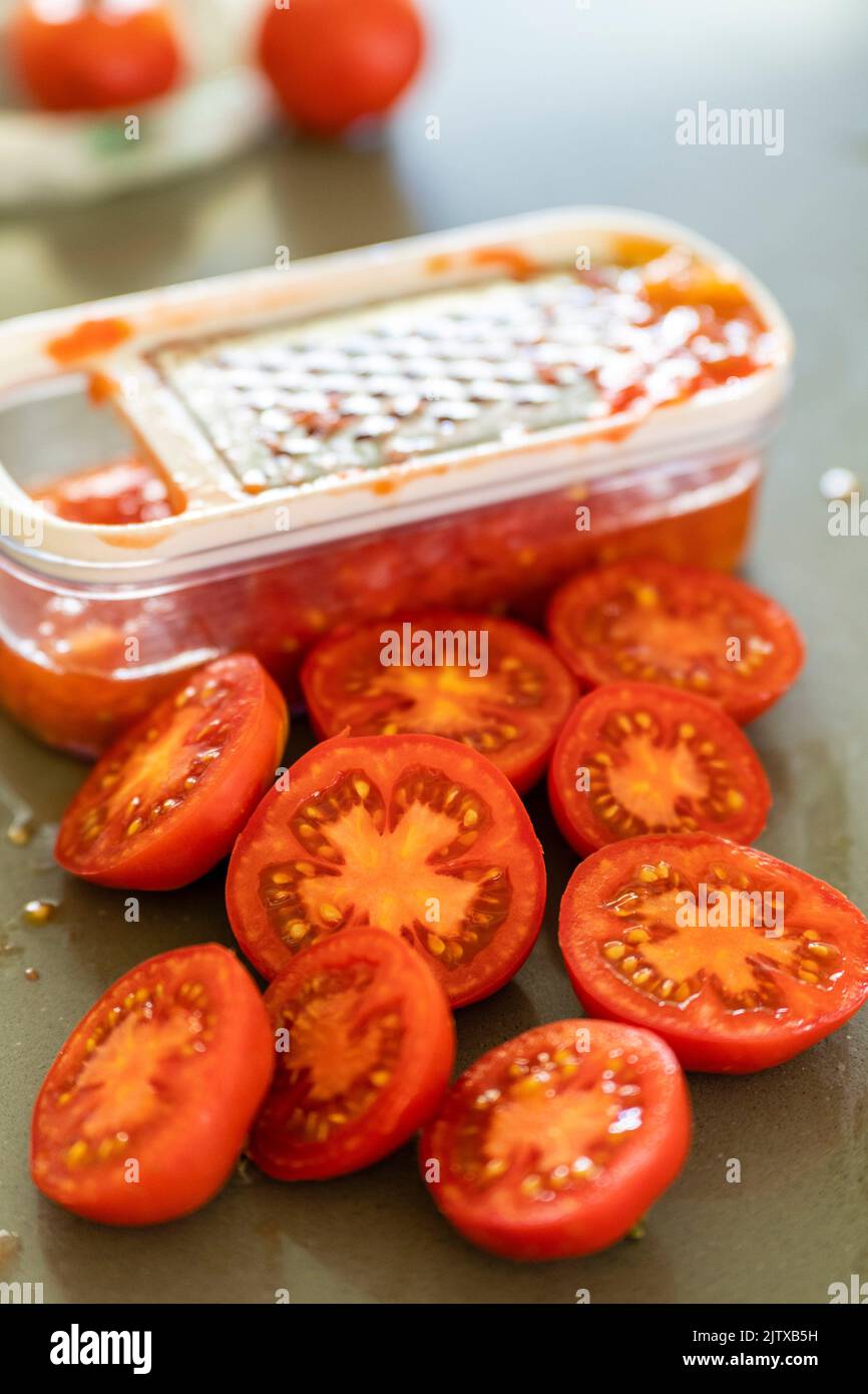 grating tomatoes for sauce, mallorca, spain Stock Photo Alamy