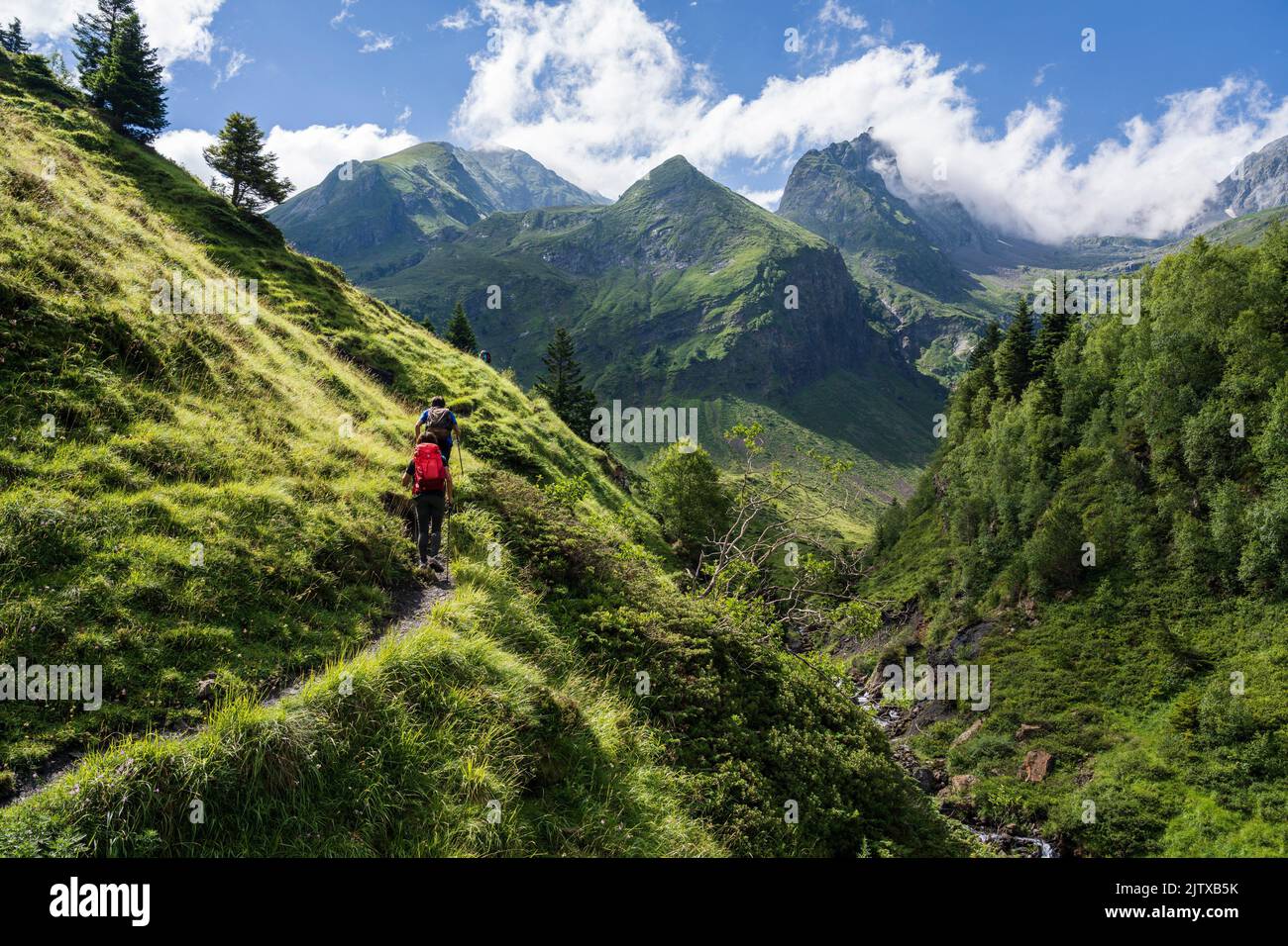 hikers on the trail, Ascending towards Hourgade Peak, L´Ourtiga, Luchon, Pyrenean mountain range, France. Stock Photo