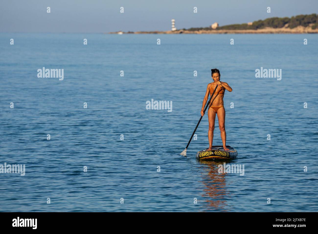 lonely woman practicing paddle surfing in the Mediterranean, Sa Rapita, Campos, Mallorca, Balearic Islands, Spain. Stock Photo
