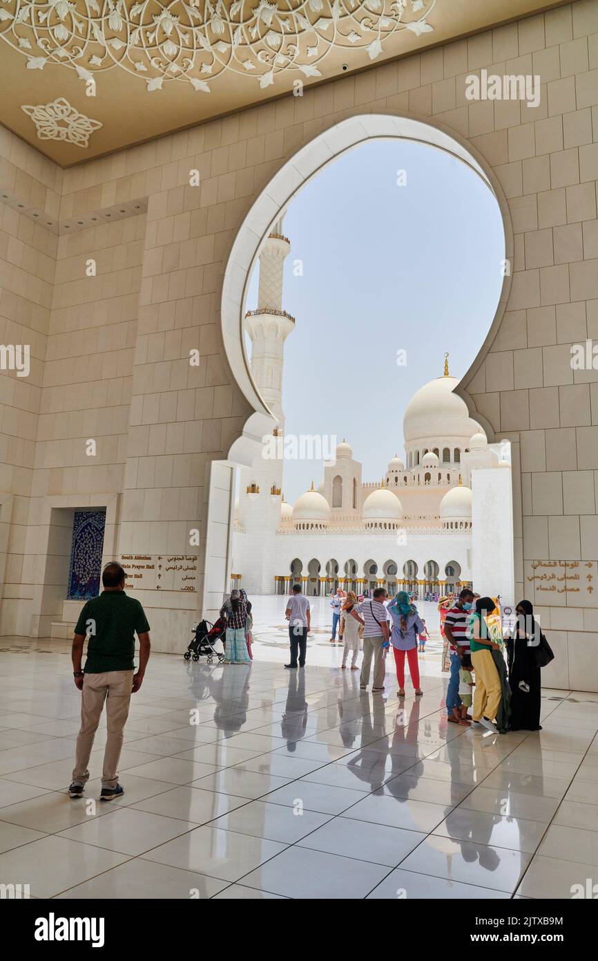 Worshippers and visitors at the entrance of Sheikh Zayed Mosque. Abu Dhabi, United Arab Emirates. Stock Photo