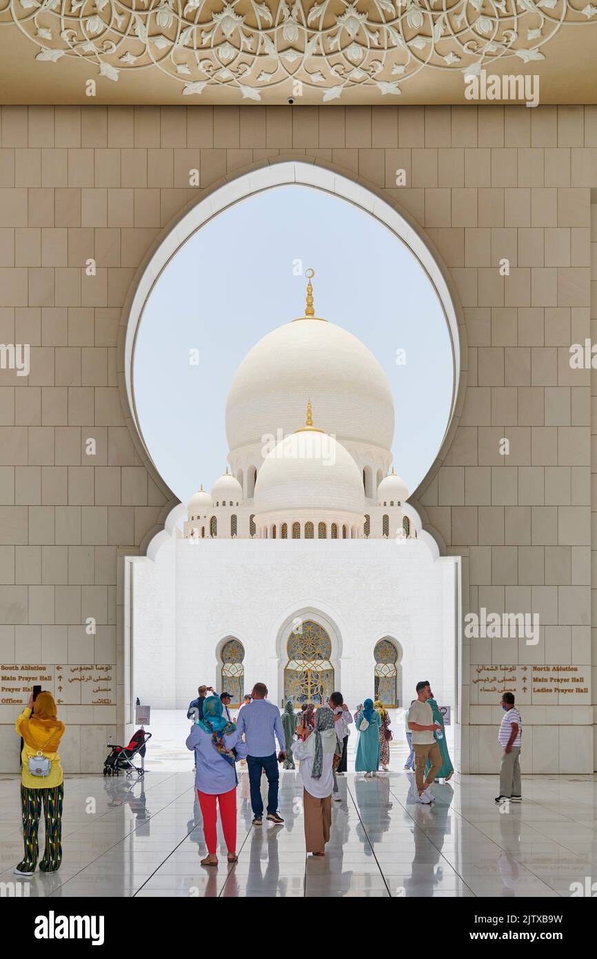 Worshippers and visitors at the entrance of Sheikh Zayed Mosque. Abu Dhabi, United Arab Emirates. Stock Photo