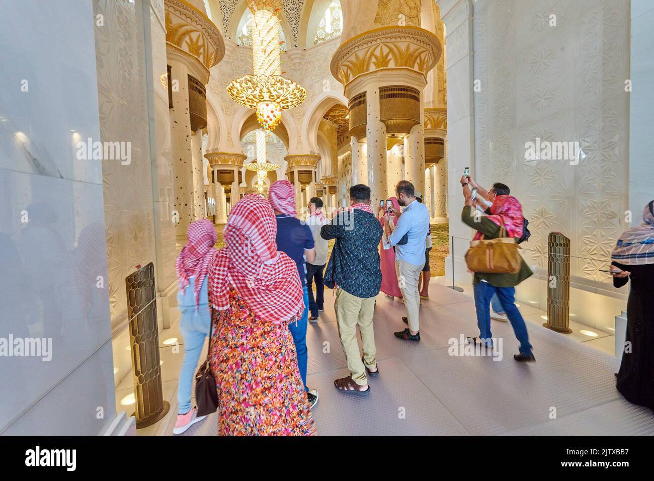 Tourists taking photos at the entrance of the prayer room at Sheikh Zayed Mosque. Abu Dhabi. United Arab Emirates. Stock Photo