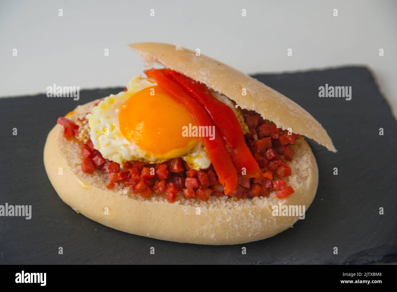 Tapa made of fried egg, picadillo and red pepper in bread. Spain. Stock Photo