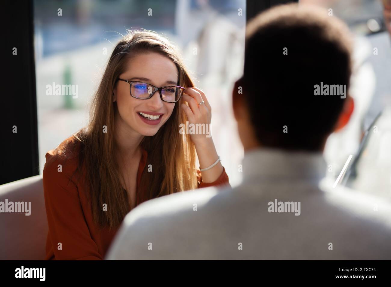 Friends in a restaurant talking smiling and drinking tea. Business colleagues having a meeting after work or during coffee break at a cafe bar. Stock Photo