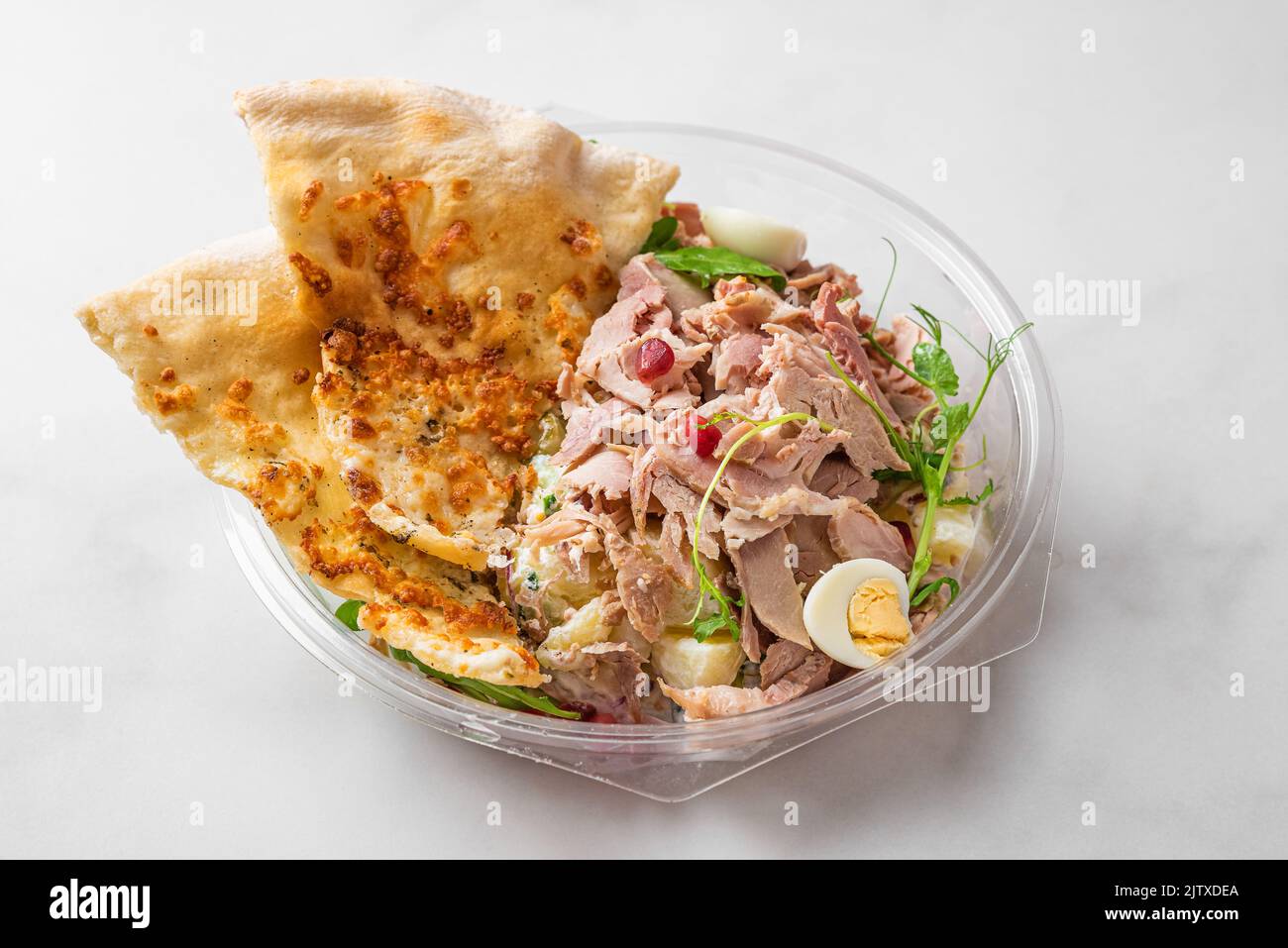 Healthy baked ham salad with arugula, crust bread toast, pomegranate in plastic package container for take away. Food in lunch box Stock Photo