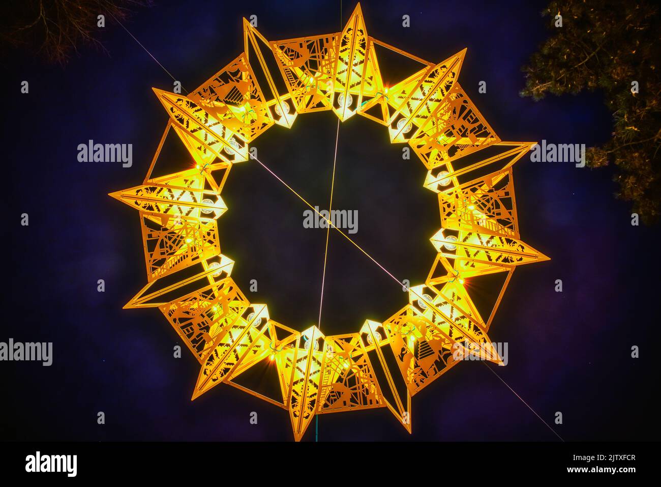 Symmetric yellow star (tetradecagonYellow star (tetradecagon or fourteen sided polygon) made of bright light shining in the night sky. Tetrakaidecagon Stock Photo