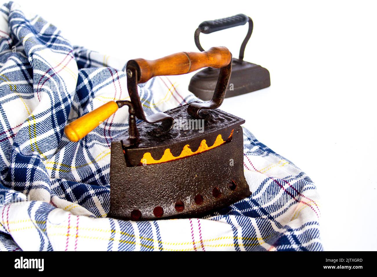 Image of old coal-fired irons with a shirt to be ironed. Old memories and customs Stock Photo