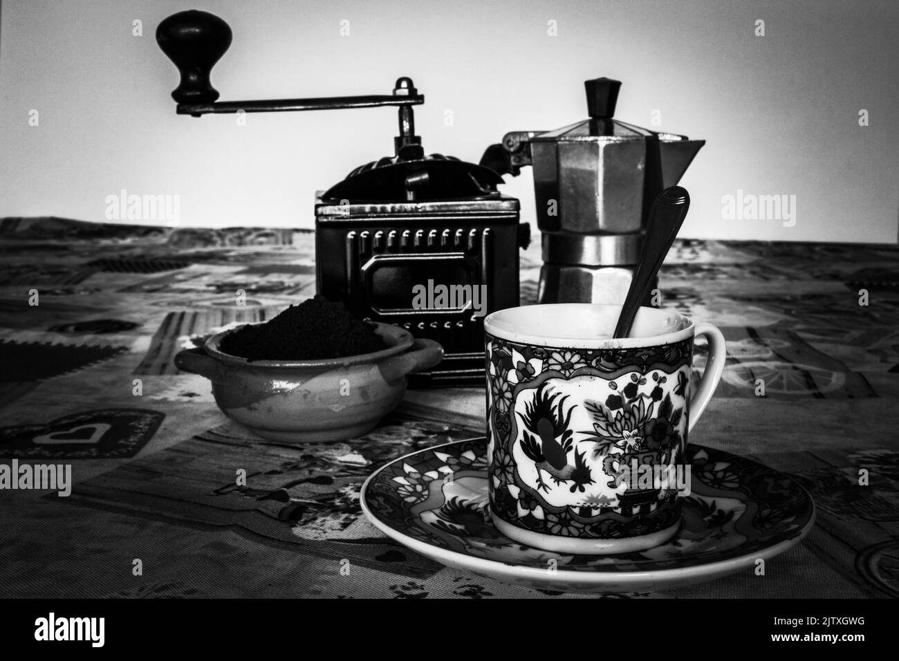 Image of a coffee cup, a coffee grinder and a mocha machine. Breakfast with an espresso.Vintage black and white photo Stock Photo
