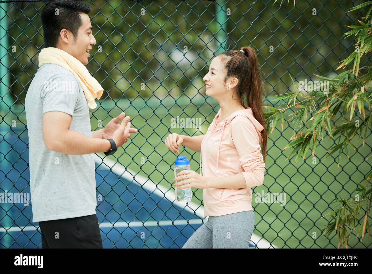 Sporty young couple chatting and drinking water after training Stock Photo