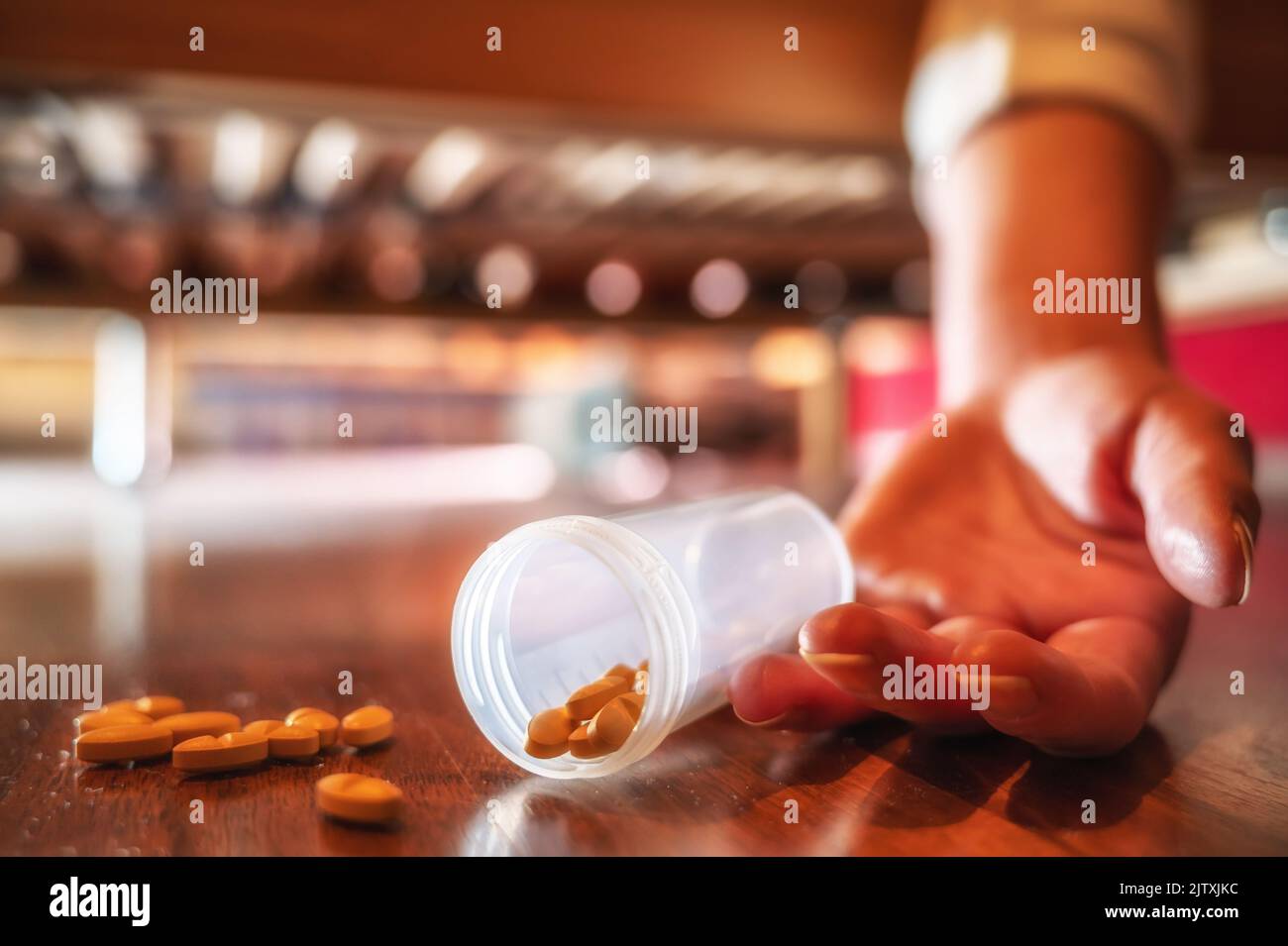 Dangerous abuse of sleeping pills with dropped tablets and a lifeless hand Stock Photo