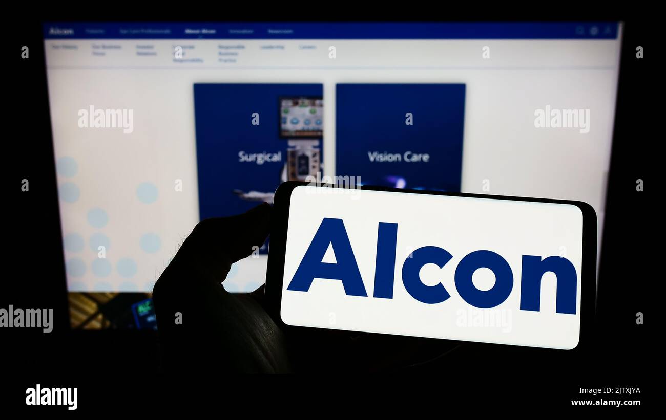 Person holding cellphone with logo of eye care company Alcon AG on