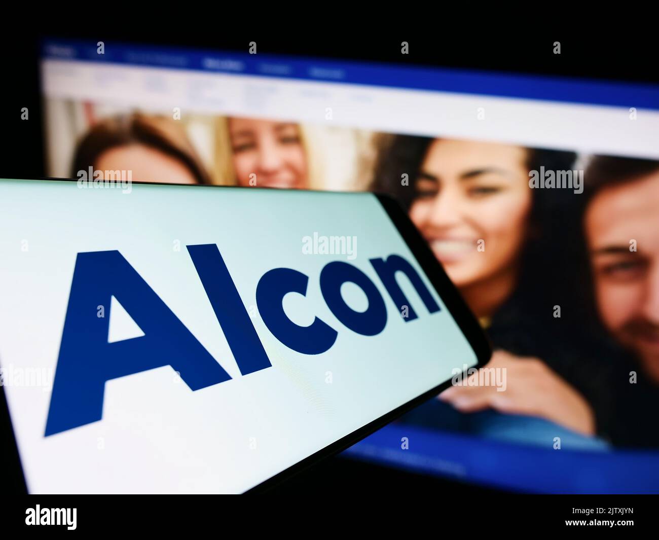 Smartphone with logo of eye care company Alcon AG on screen in front of