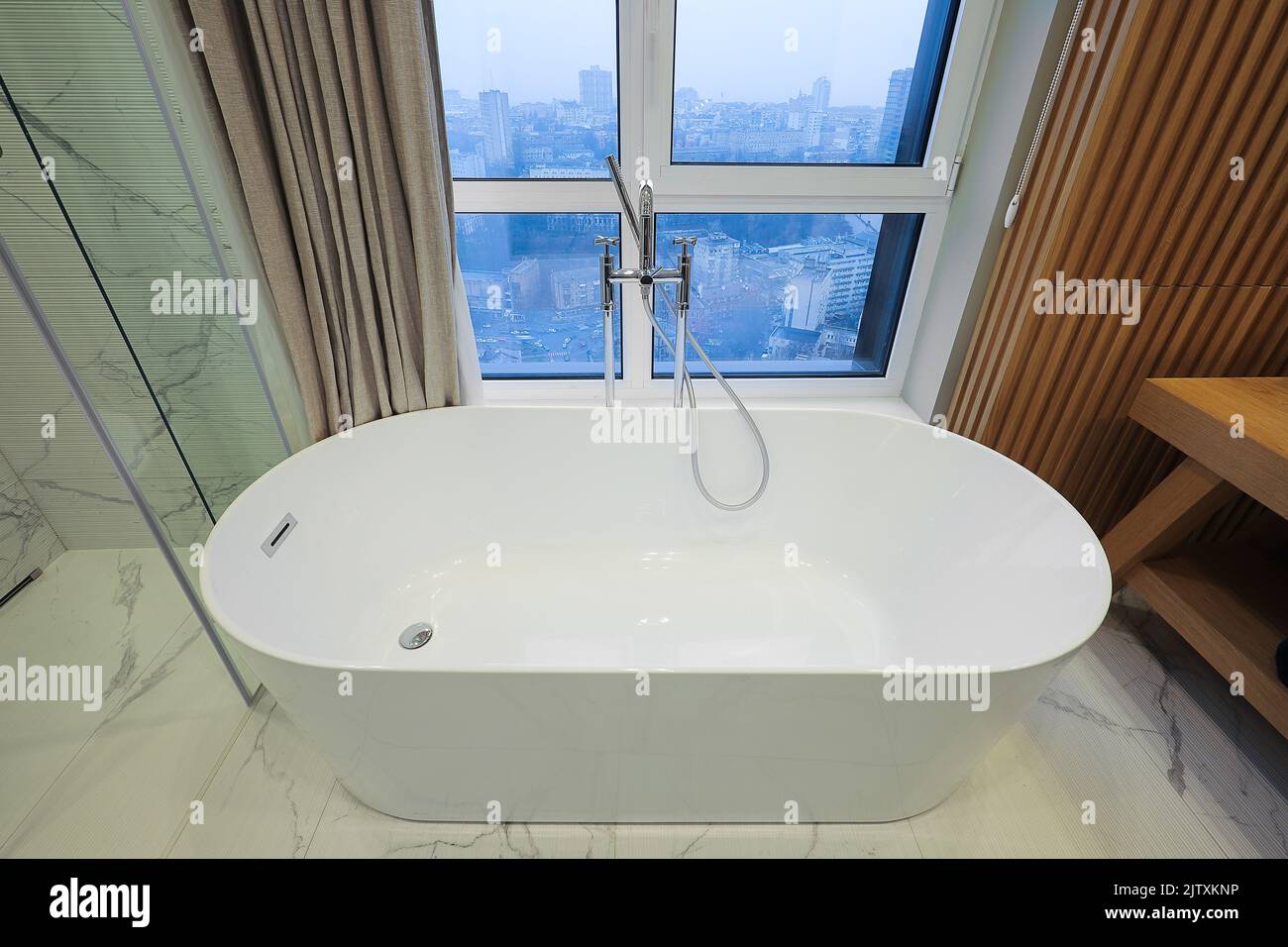 Freestanding white bathtub in the bathroom interior Stock Photo