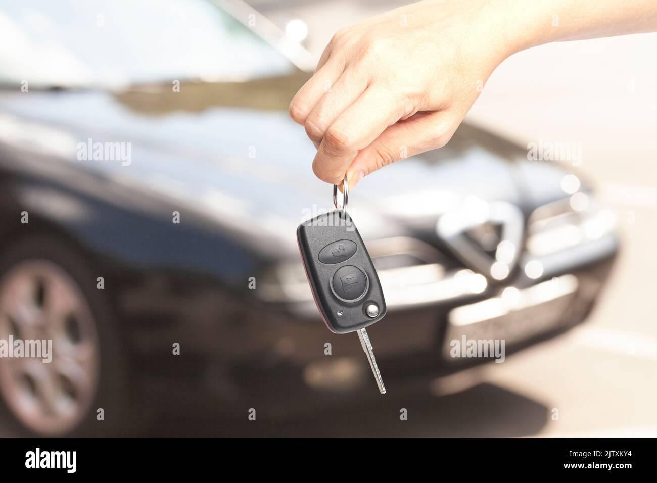 Car key in woman's hand with a car blurred in the background Stock ...