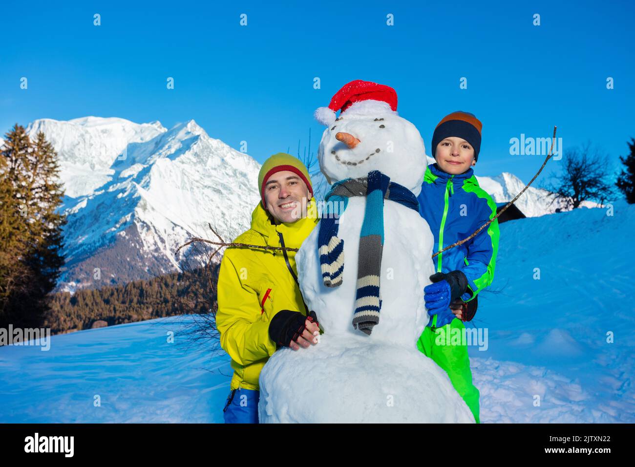 Family fun father and a boy build snowman with in scarf, carrot Stock Photo