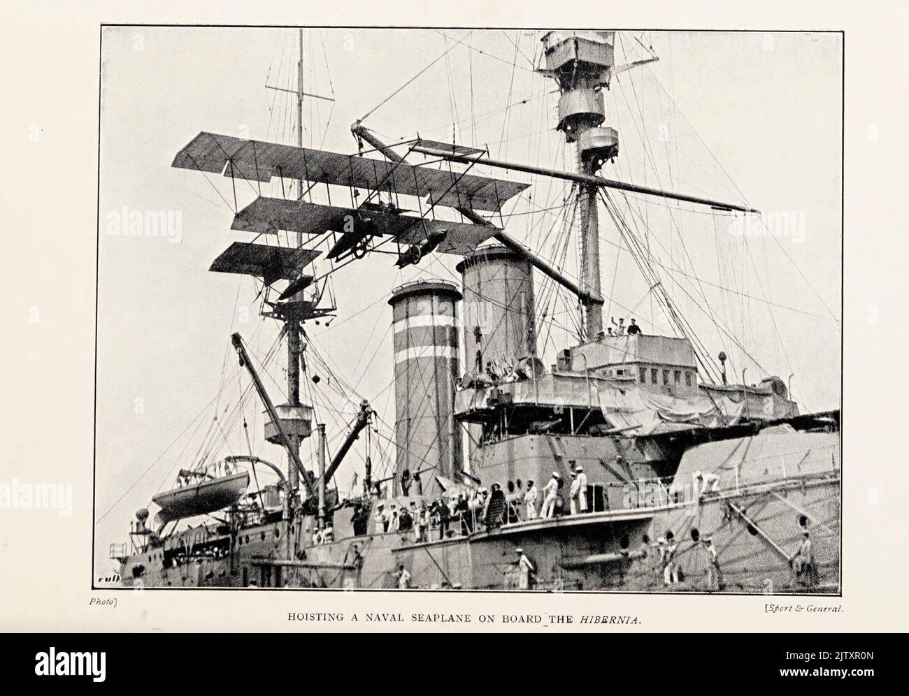 HOISTING A NAVAL SEAPLANE ON BOARD THE HMS HIBERNIA from the book ' The British battle fleet : its inception and growth throughout the centuries to the present day ' Volume 2 by Jane, Fred T., 1865-1916 Publication date 1915 Stock Photo