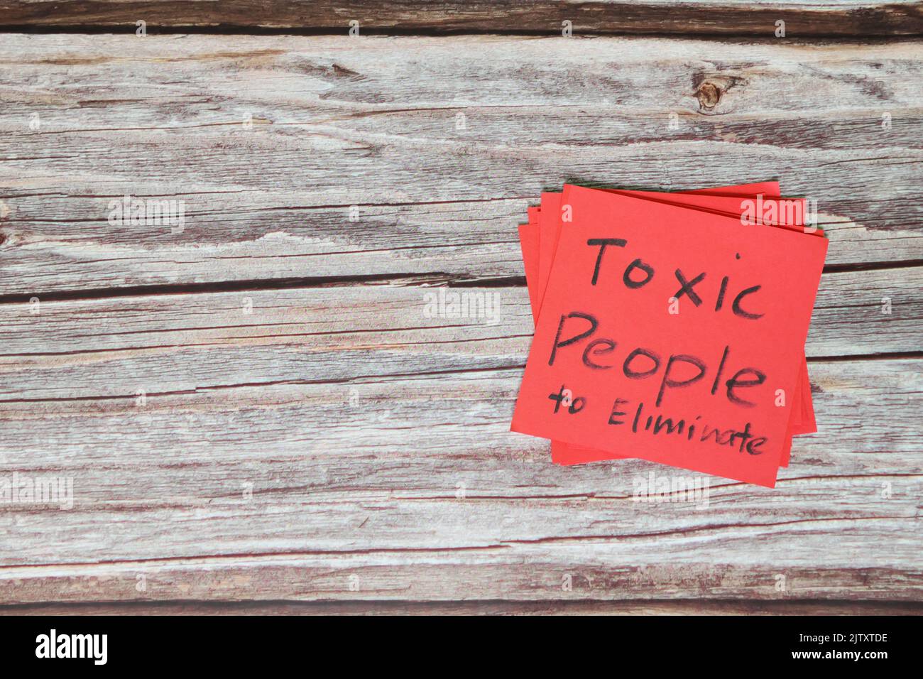 List of toxic people to eliminate concept. Red sticky note in wooden background with copy space. Stock Photo