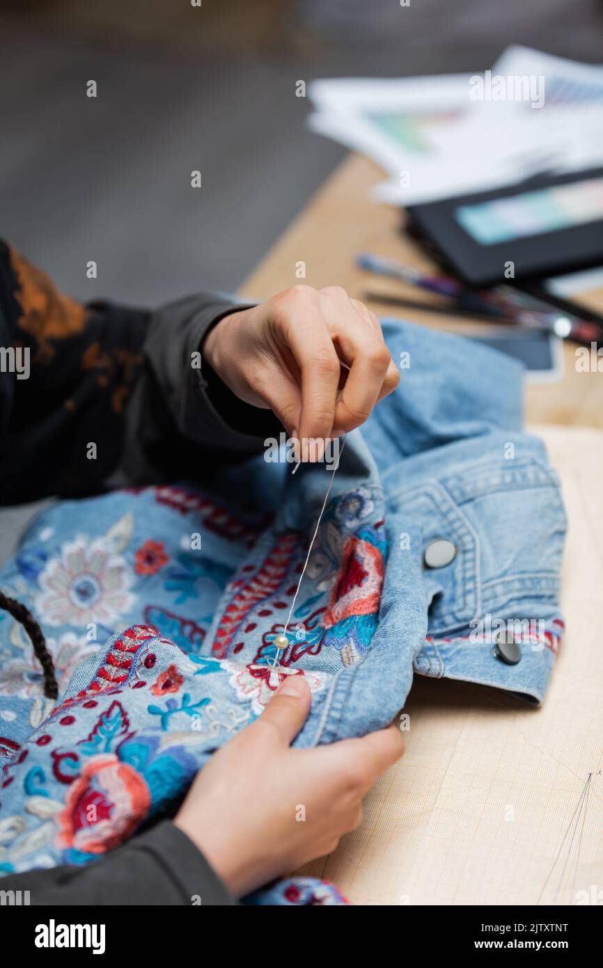 Cropped view of african american craftswoman embroidering denim jacket,stock image Stock Photo