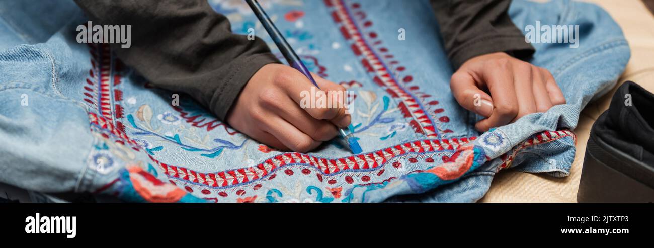 Cropped view of african american craftswoman painting on denim jacket with embroidery, banner,stock image Stock Photo
