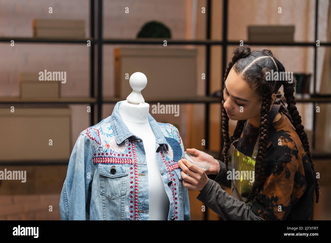 African american designer decorating denim jacket in workshop,stock image Stock Photo