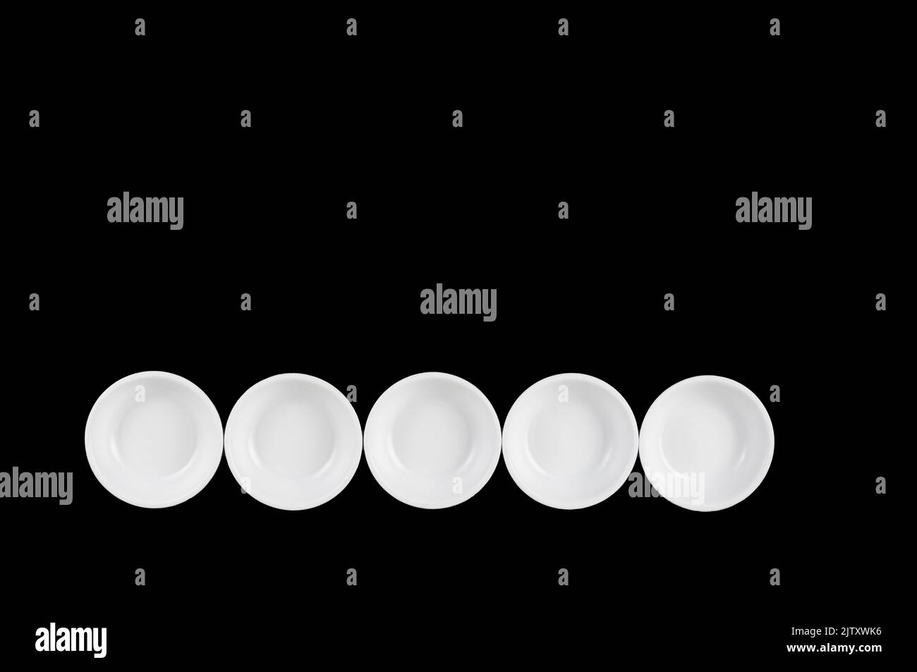 white dishes bowls on a black background Stock Photo