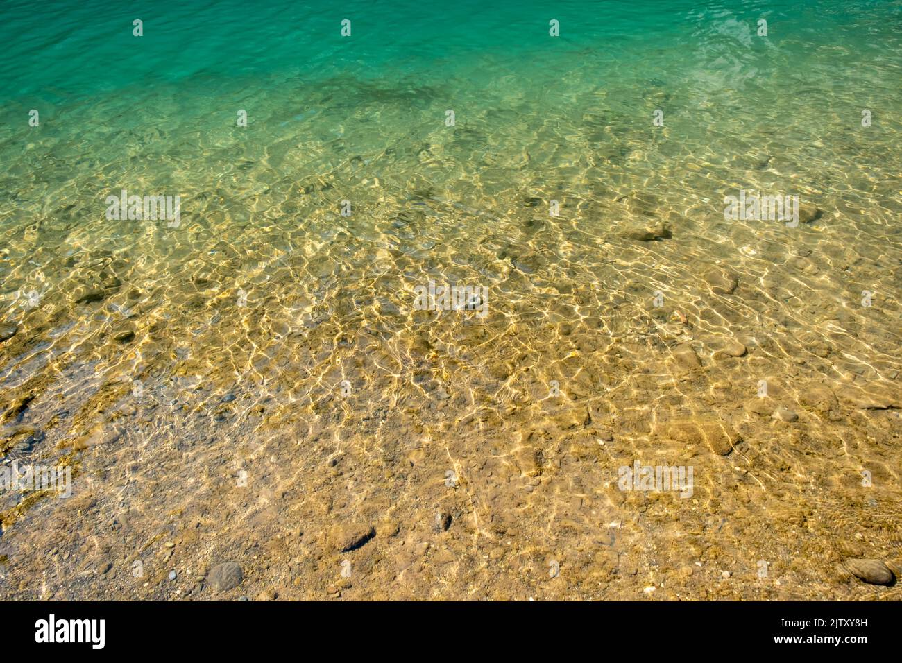 Ripple water abstract background with small pebbles Stock Photo