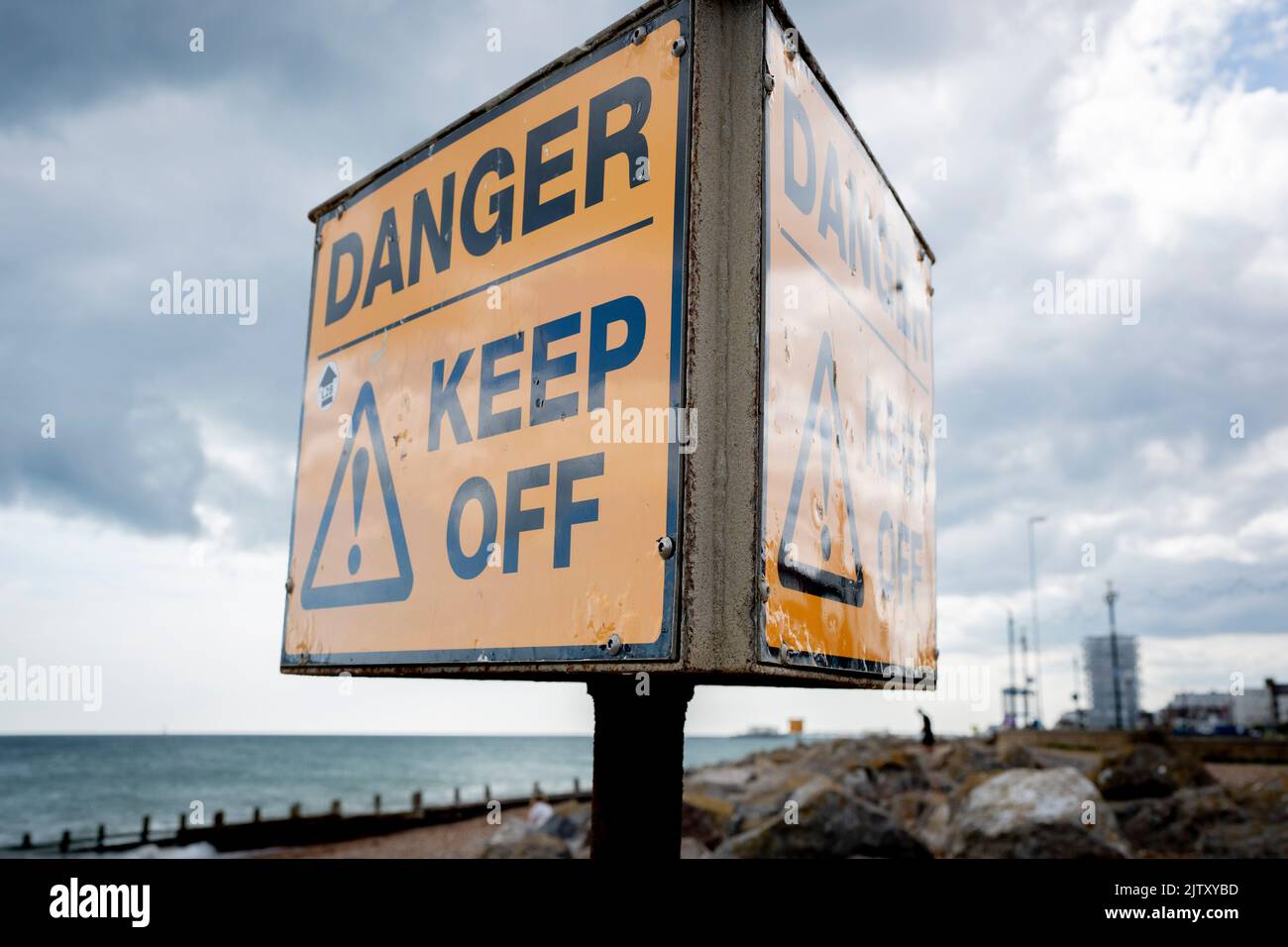 A danger keep off warning sign is seen on sea defence rocks on the shingle beach at Worthing, on 29th August 2022, in Worthing, England. Stock Photo