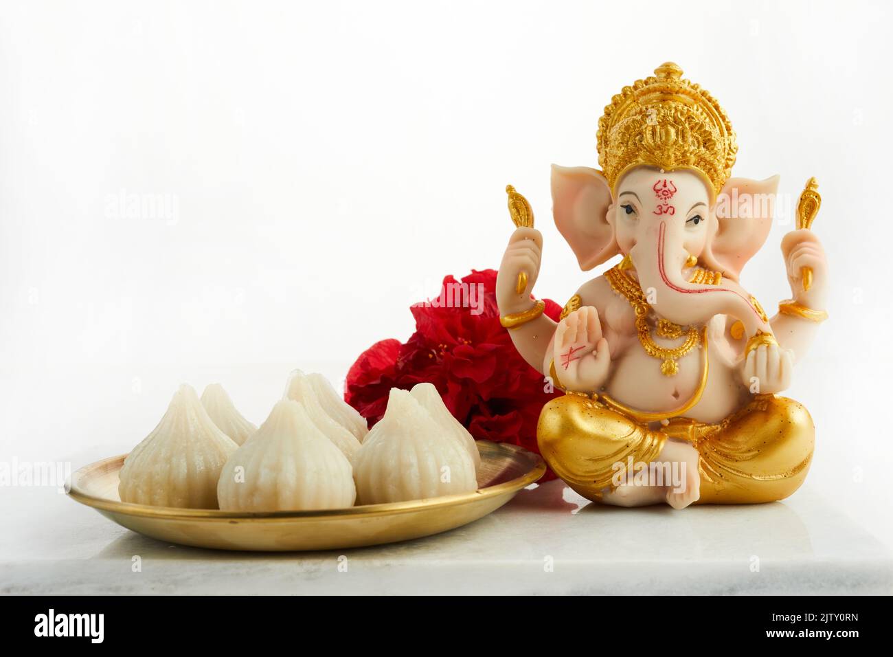 Idol of lord Ganesha with Modak Sweet Dish and flower. Ganesh chaturthi Stock Photo