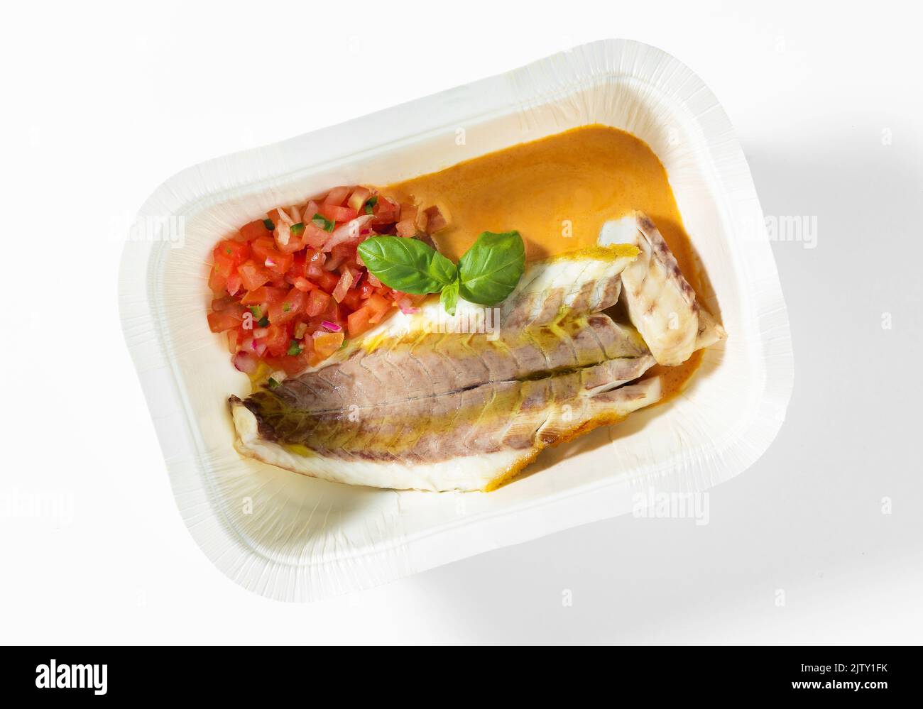Grilled sea bass fillet with tomato basil  salad and gravy on white in a plastic container box , for delivery Stock Photo