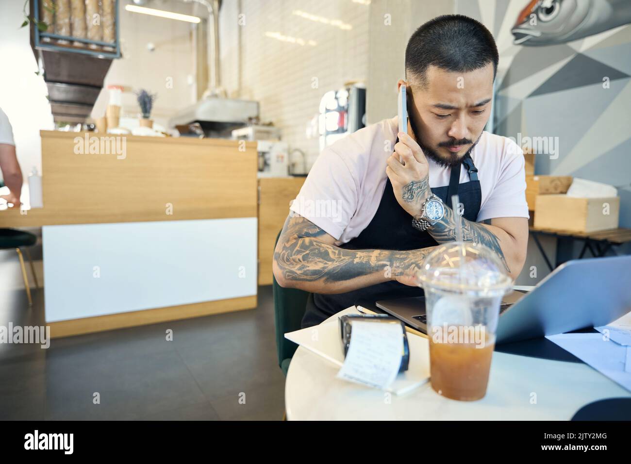 Preoccupied young man sorting out his work at coffee shop Stock Photo