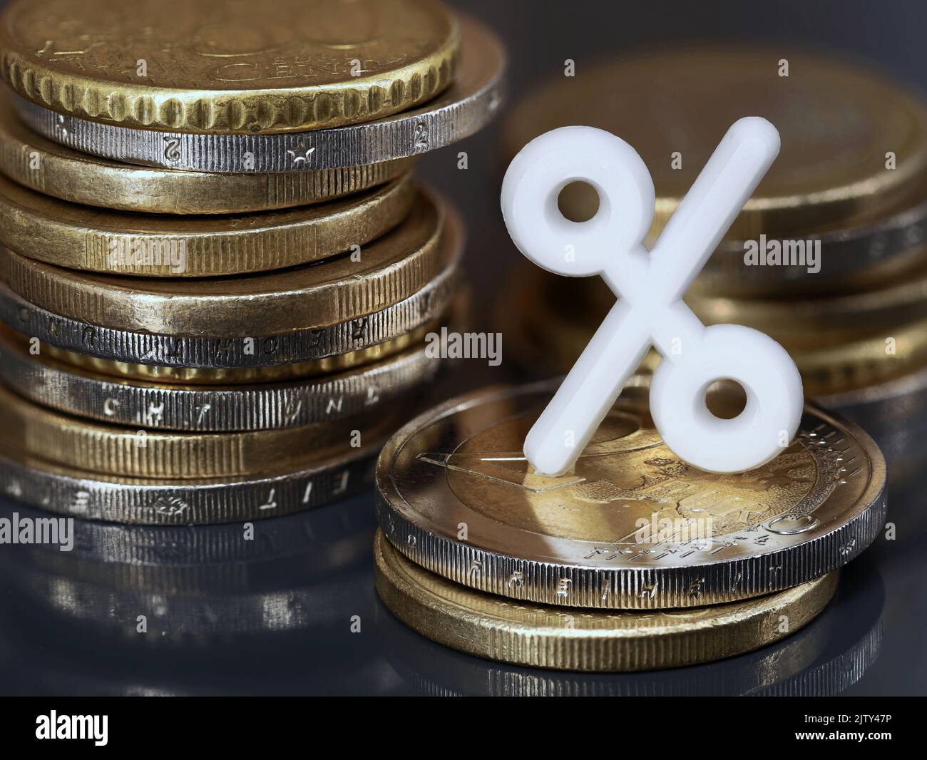 Stacks of euro coins with white percent sign, concept of investing money or getting a discount to save money Stock Photo