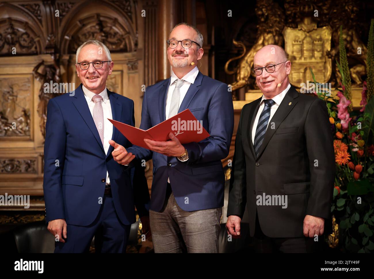 02 September 2022, Hamburg: Anthony Hyman (m), British cell biologist,  stands with his award between Lothar Dittmer (l), Chairman of the Executive  Board of the Körber Foundation, and Martin Stratmann, President of