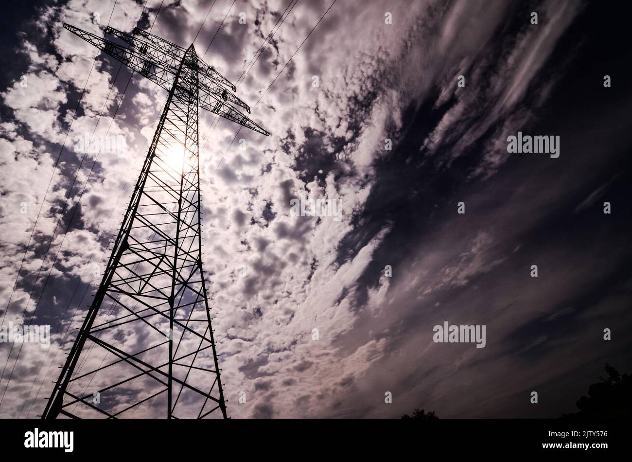 A high voltage electric transmission tower against the cloudy sky Stock ...