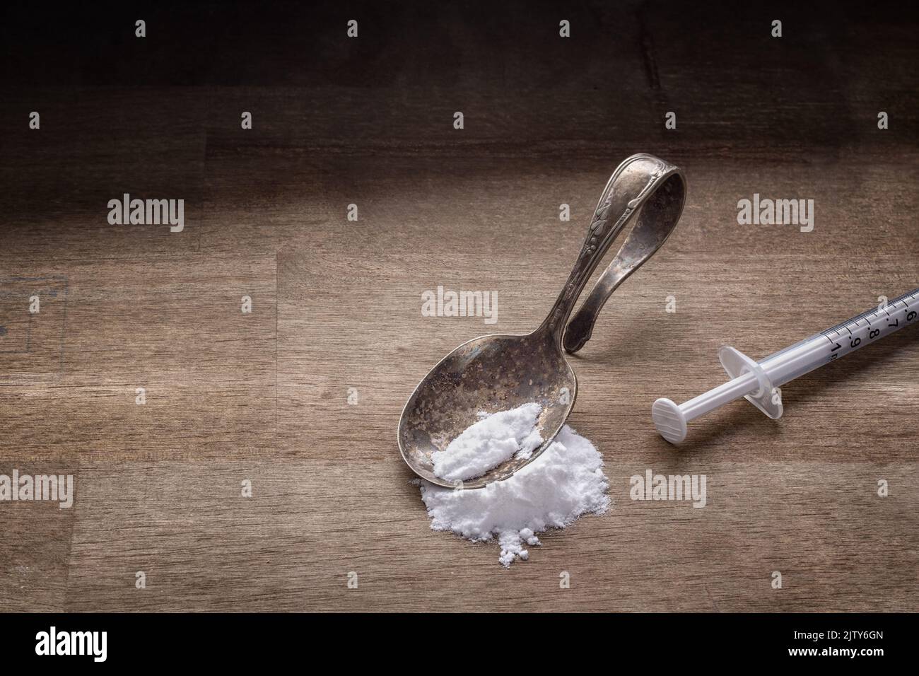 Drug addiction concept with spoon, syringe and white powder on wood Stock Photo