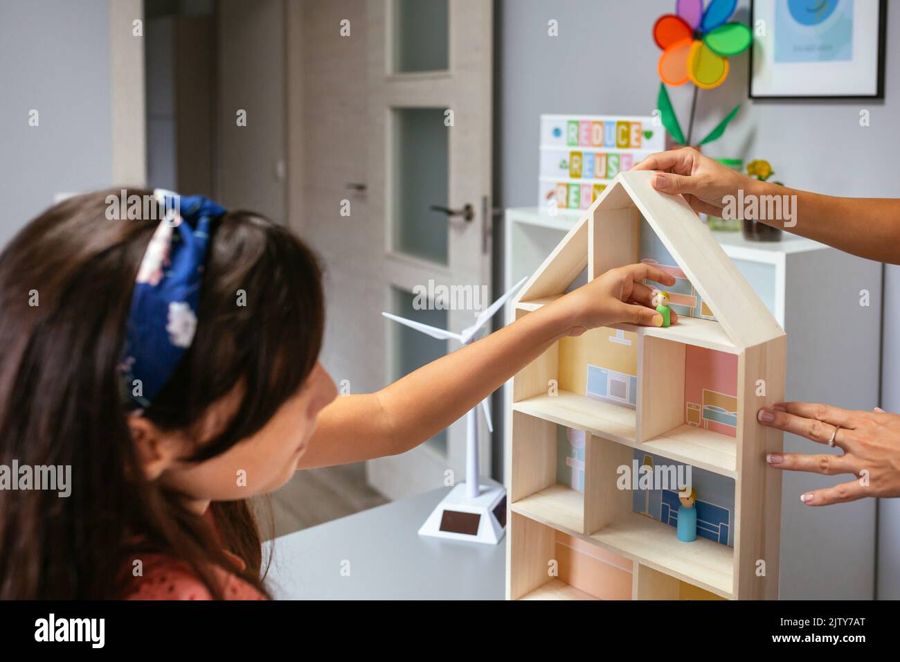 Student in an ecology classroom placing dolls in a house Stock Photo