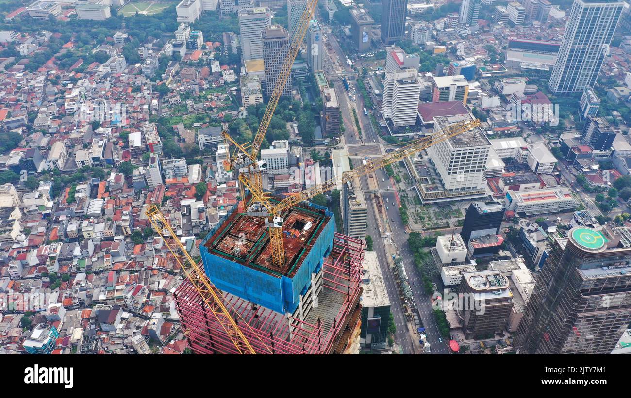 Hi-rise skeleton construction site with the yellow crane Stock Photo ...