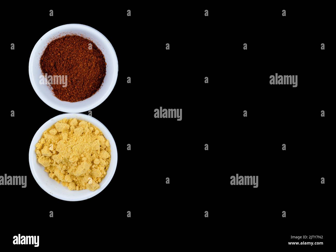 Yellow mustard and red Chilli powder in White bowls on a black background Stock Photo