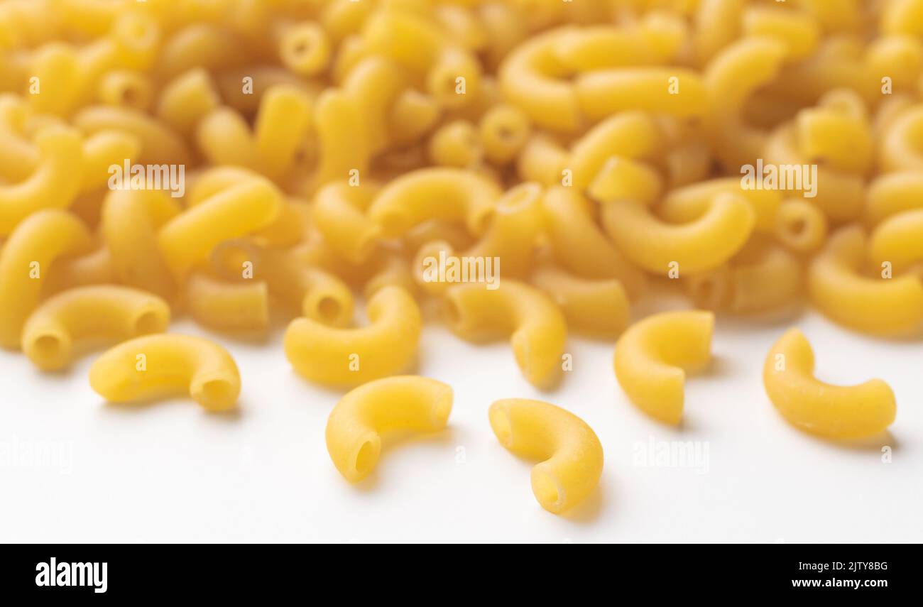 Uncooked macaroni with selective focus on front noodle Stock Photo