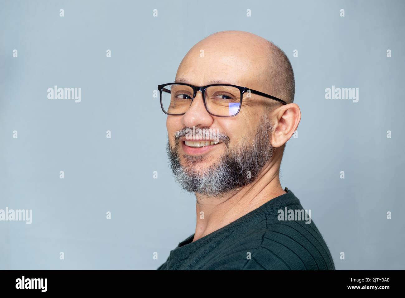 Portrait of mature man standing on light background. Bearded bald man in glasses. Formal style. Stock Photo