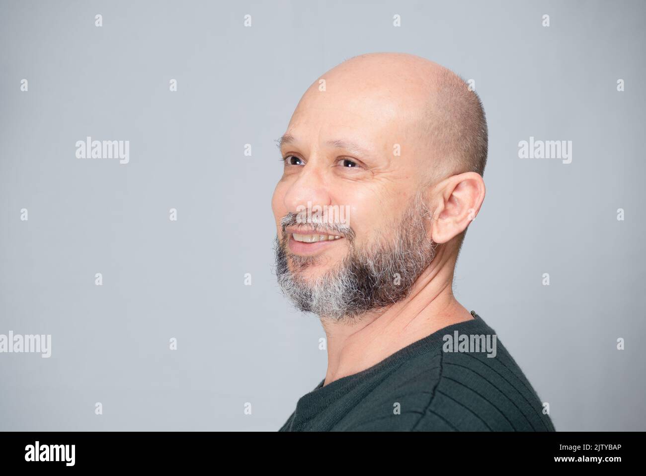 Portrait of mature man standing on light background. Bald bearded man. Formal style. Stock Photo