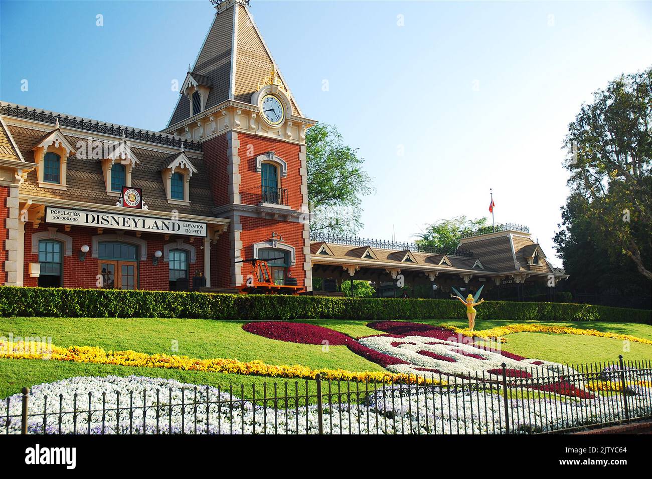 A depiction of Mickey Mouse, made of flowers in a garden, stands in front of the Disneyland train station near the entrance to the amusement park Stock Photo