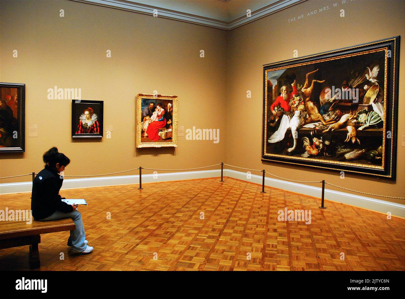A lone woman sketches a large painting hanging in the Art Institute of Chicago museum Stock Photo