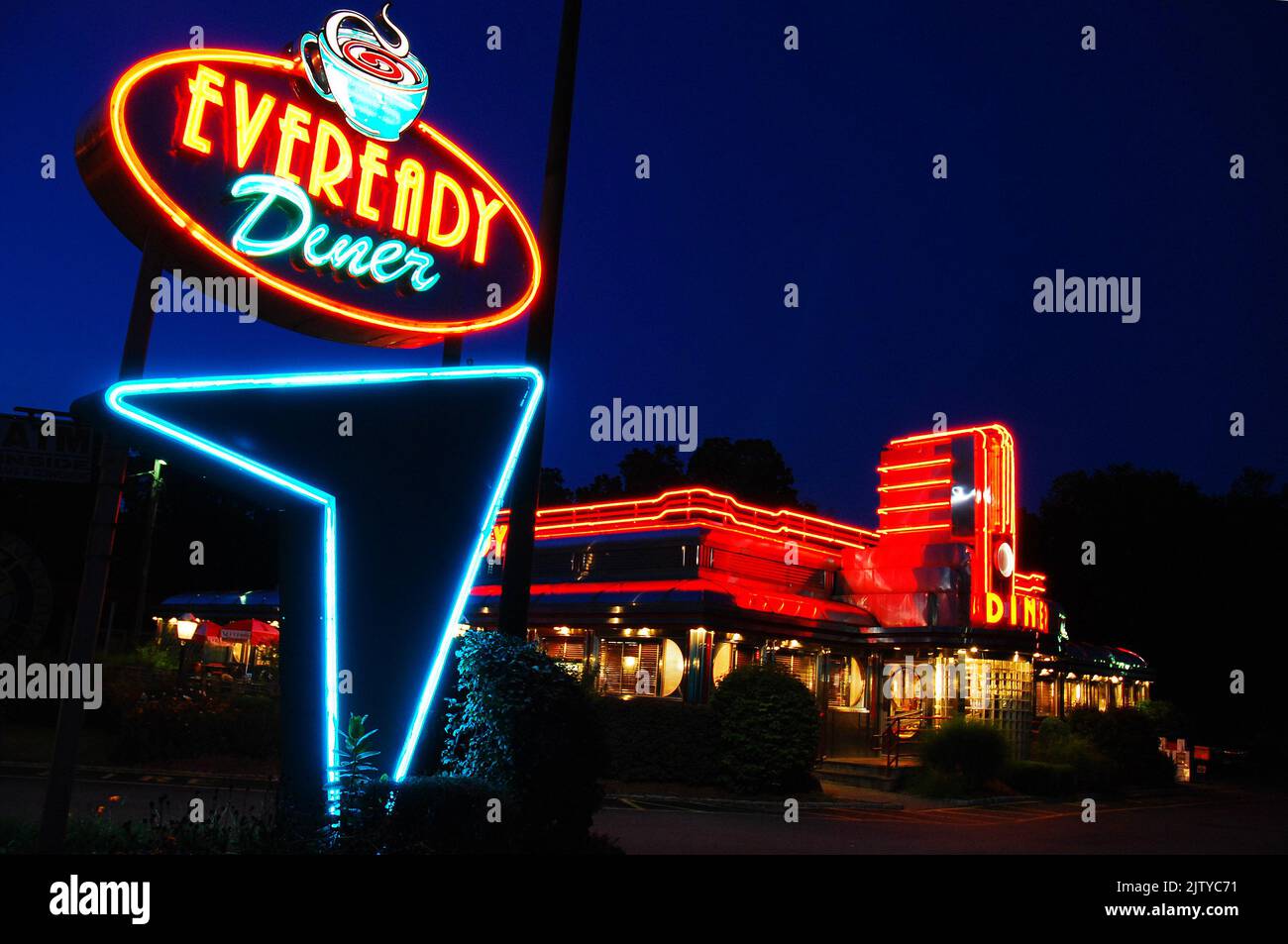 An illuminated neon light sign marks the entrance to the Eveready Diner, a retro architecture restaurant and cafe at night in the Hudson Valley Stock Photo