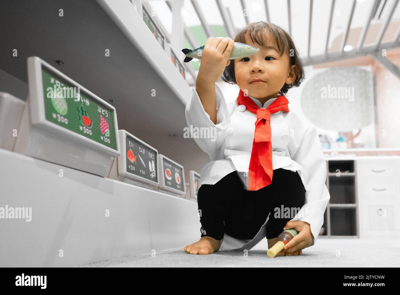 A toddler chef play pretend. Chef cook costume attire. Asian-Filipino girl. Stock Photo