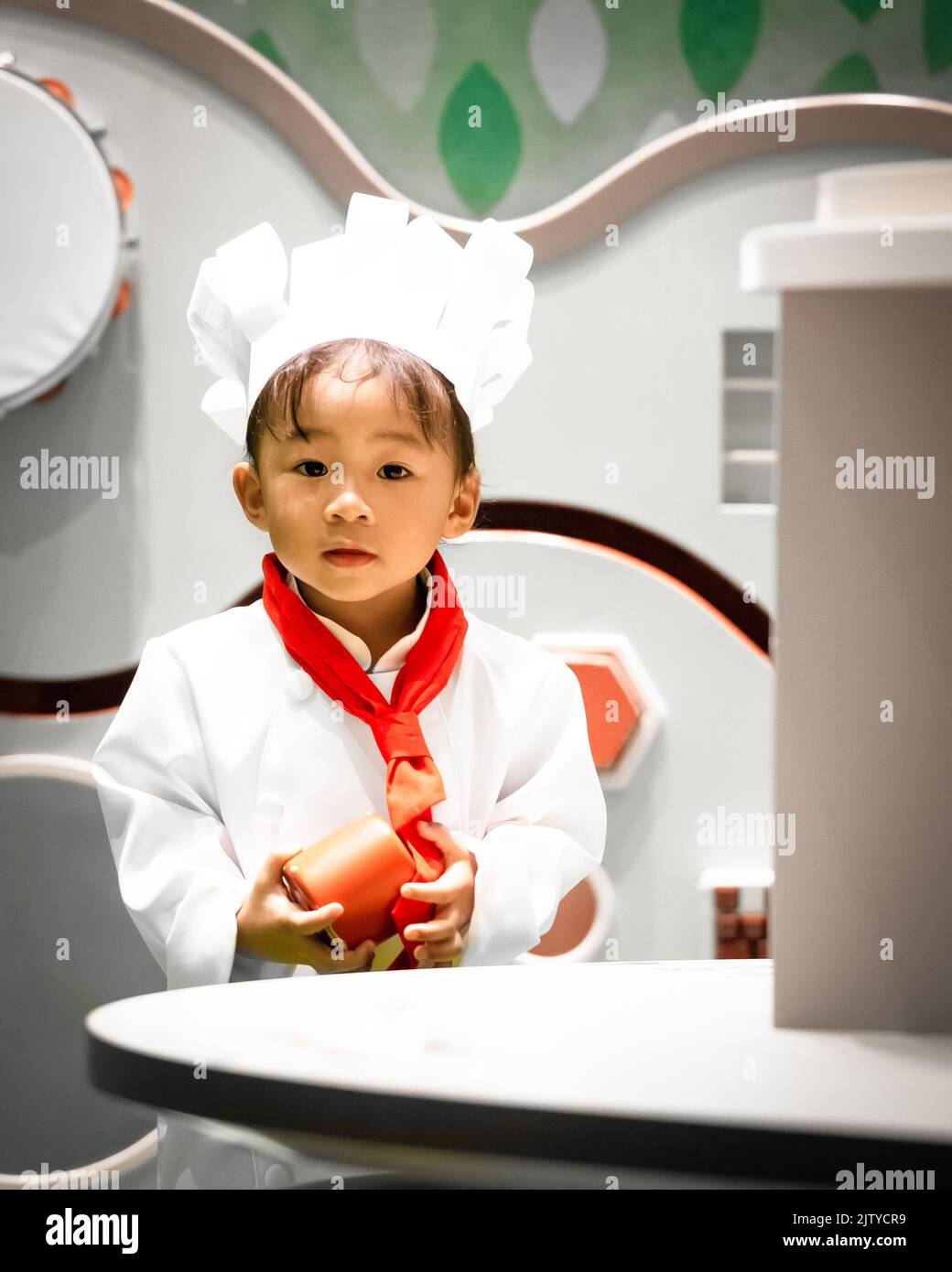 A toddler chef play pretend. Chef cook costume attire. Asian-Filipino girl. Stock Photo