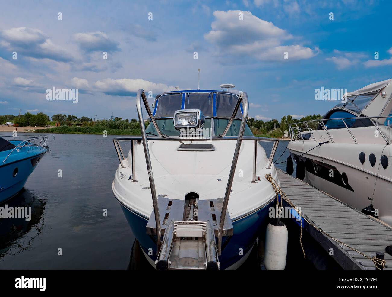 Boats moored to a pier in a yacht marina. Summer vacations and tourism ...