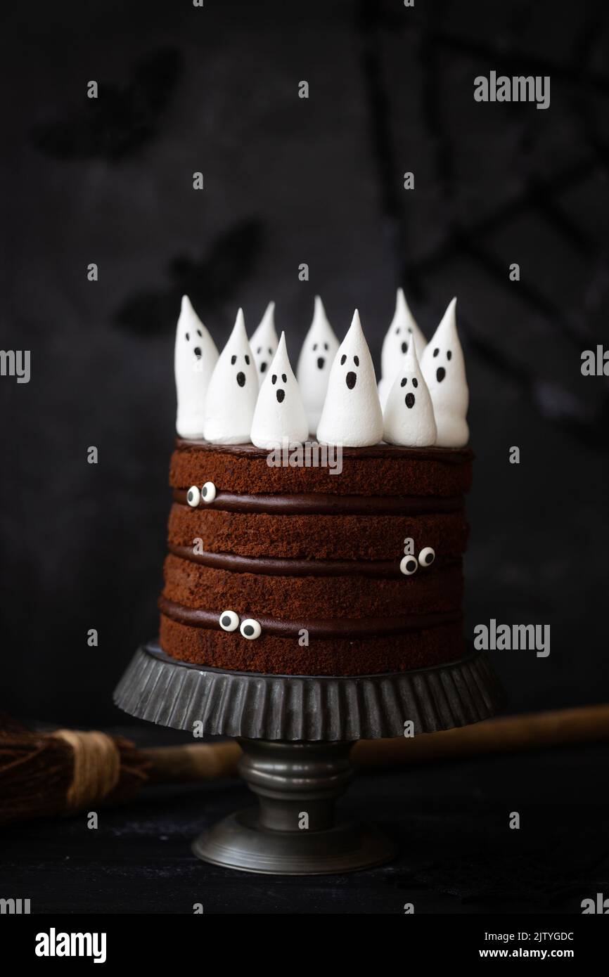 Chocolate Halloween cake with spooky meringue ghosts and candy eyes Stock Photo