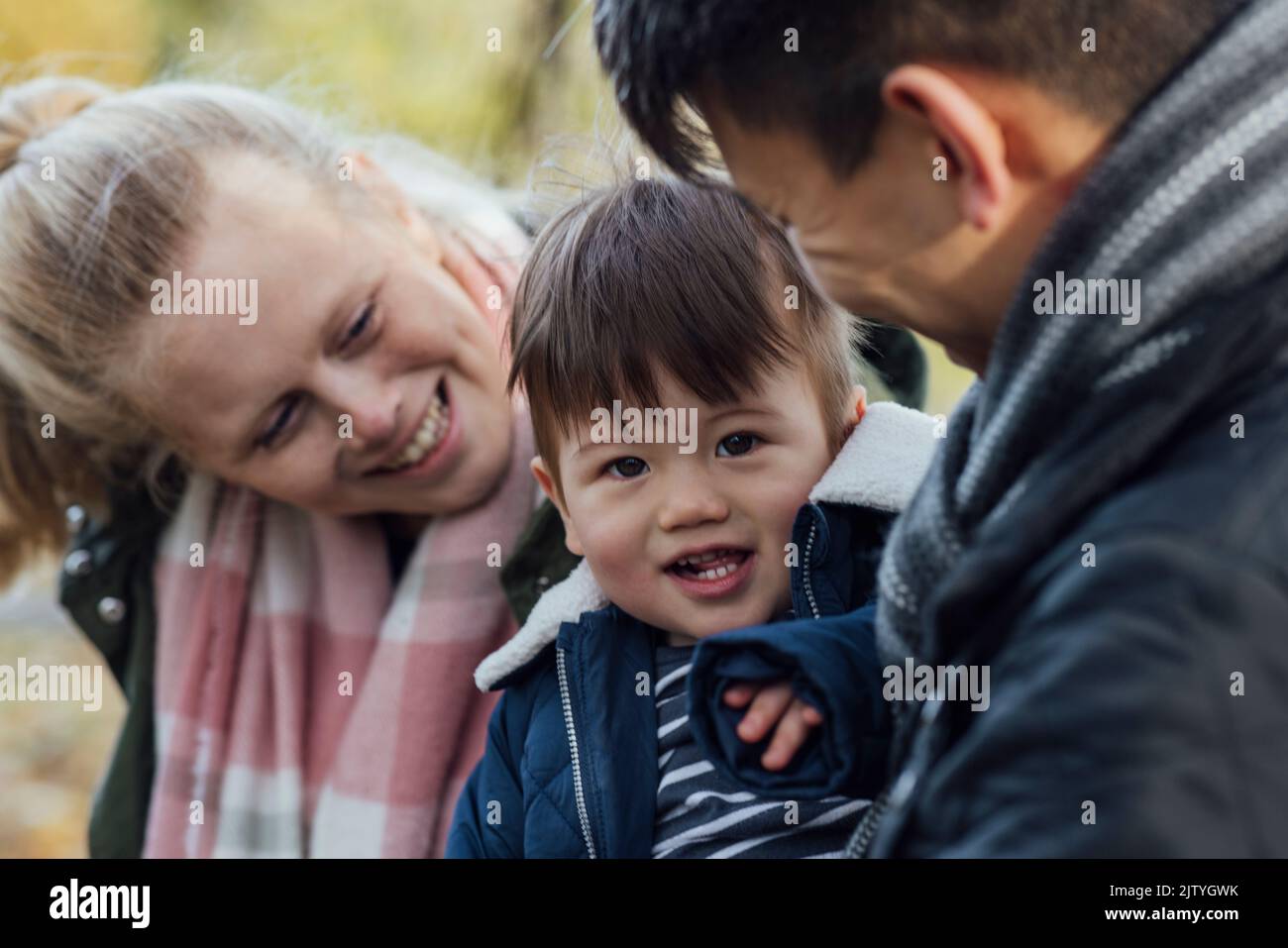 A family spending a day in nature together in Northumberland, North East England during Autumn. The parents are looking at their baby boy while the bo Stock Photo