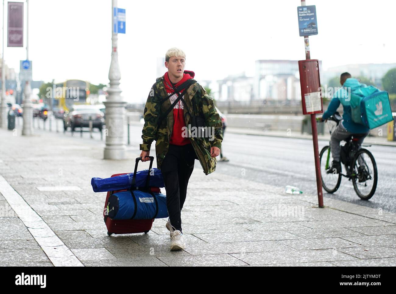 A concert goer arrives for a bus to Electric Picnic at the Customs House, Dublin, as Met Éireann has issued a status yellow weather warning for wind and rain for the weekend.The music and arts festival takes place in Stradbally, County Laois, between 2 and 4 September 2022. Picture date: Friday September 2, 2022. Stock Photo